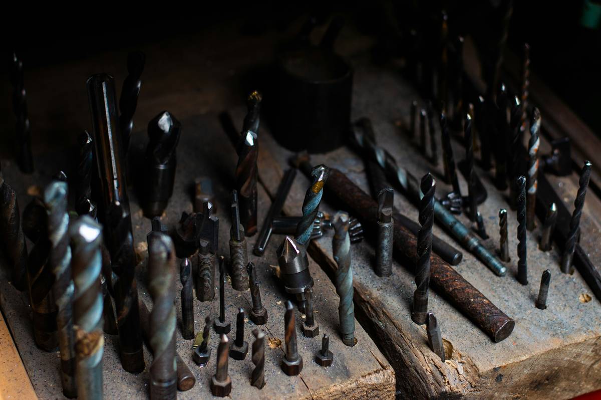 different types of routers woodworking: fixed-base, plunge, and trim routers displayed on a workshop bench with common accessories