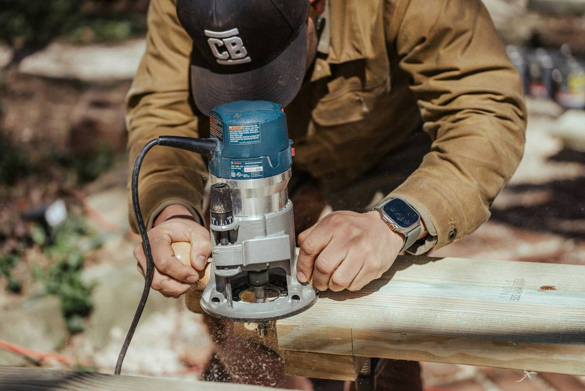 what is a router tool: close-up of a handheld router shaping a wooden edge
